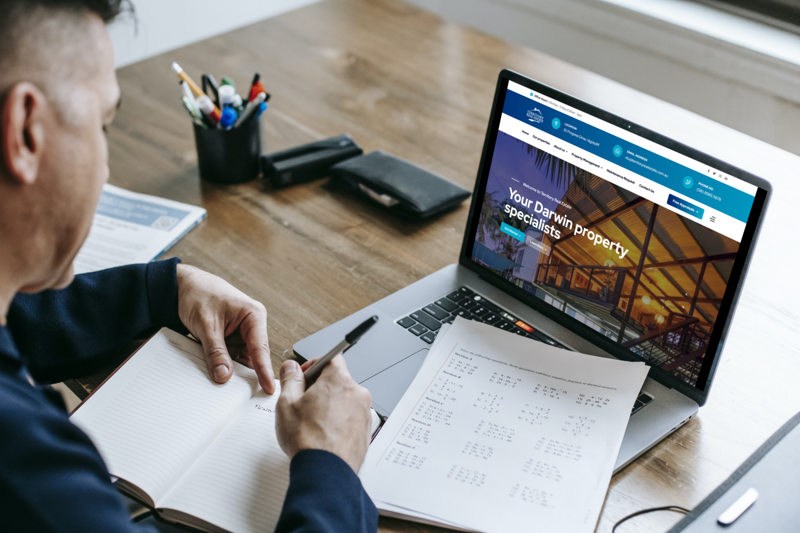 Man using laptop to view Territory Real Estate's website